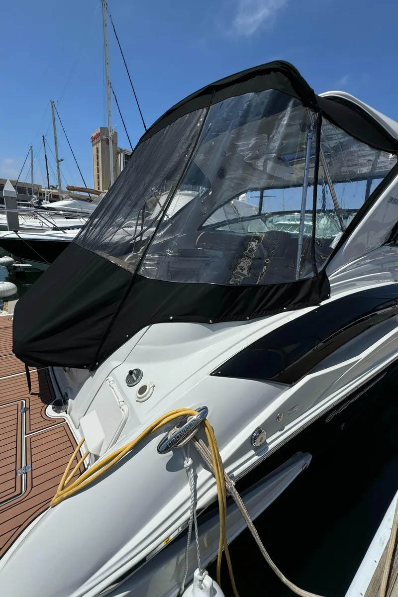 Slide: The Image of 2018 Crownline 350 SY yacht docked, featuring sleek design and protective canopy. - 15