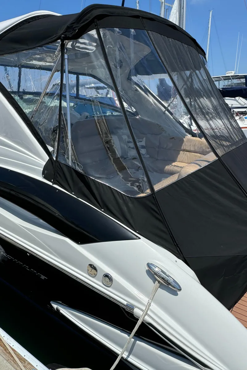 Slide: The Image of 2018 Crownline 350 SY boat with sleek design and black canopy in marina. - 16