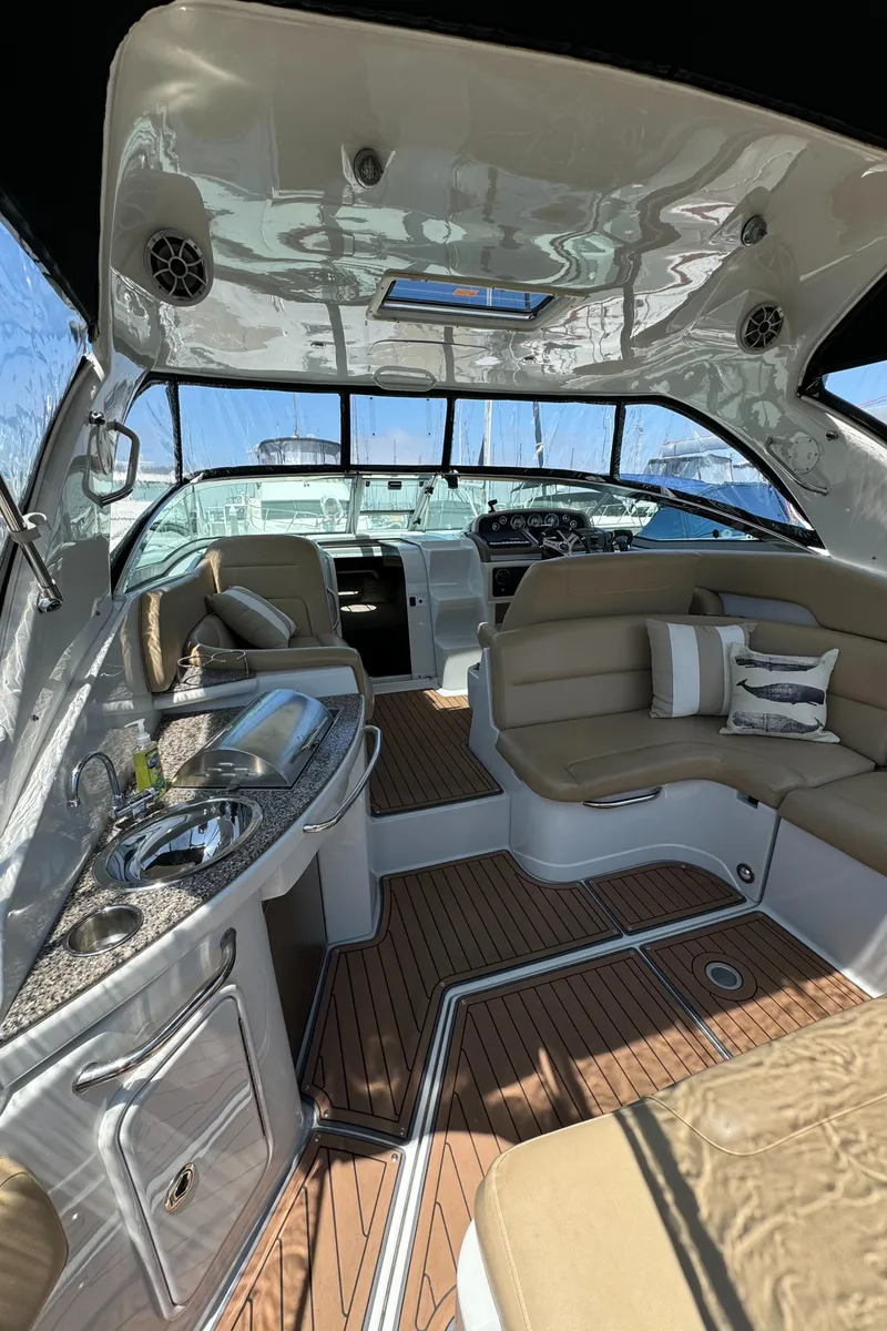 Slide: The Image of 2018 Crownline 350 SY yacht interior with seating, kitchenette, and wood flooring. - 23