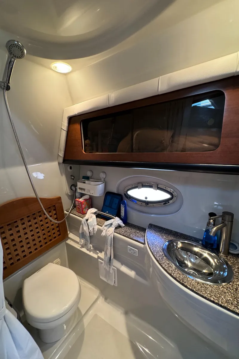 Slide: The Image of 2018 Crownline 350 SY yacht bathroom with modern fixtures and porthole window. - 26