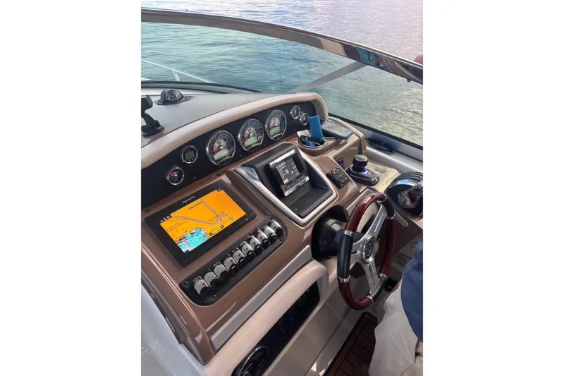 Slide: The Image of 2018 Crownline 350 SY helm with navigation screens and controls on a calm water backdrop. - 33