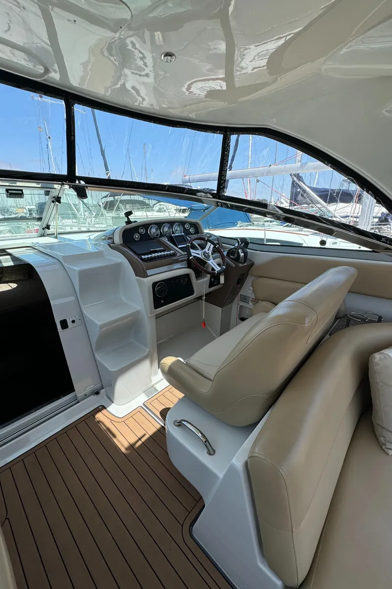 Slide: The Image of 2018 Crownline 350 SY yacht cockpit with beige seating and modern dashboard. - 36