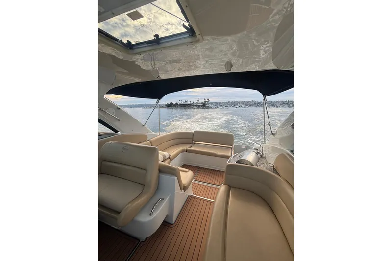 Slide: The Image of 2018 Crownline 350 SY yacht interior with beige seating and ocean view. - 4