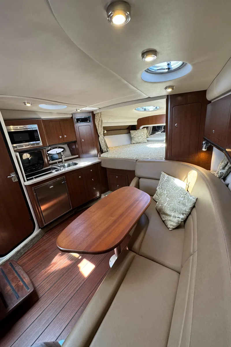 Slide: The Image of 2018 Crownline 350 SY yacht interior with kitchen, seating, and sleeping area. - 55