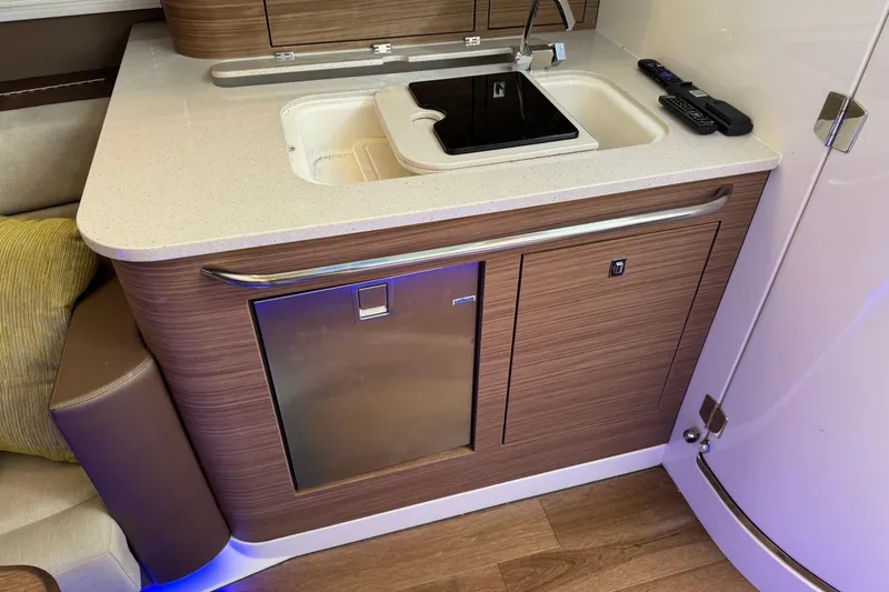 Slide: The Image of 2020 Boston Whaler 420 Outrage interior kitchenette with sink, countertop, and mini fridge. - 14