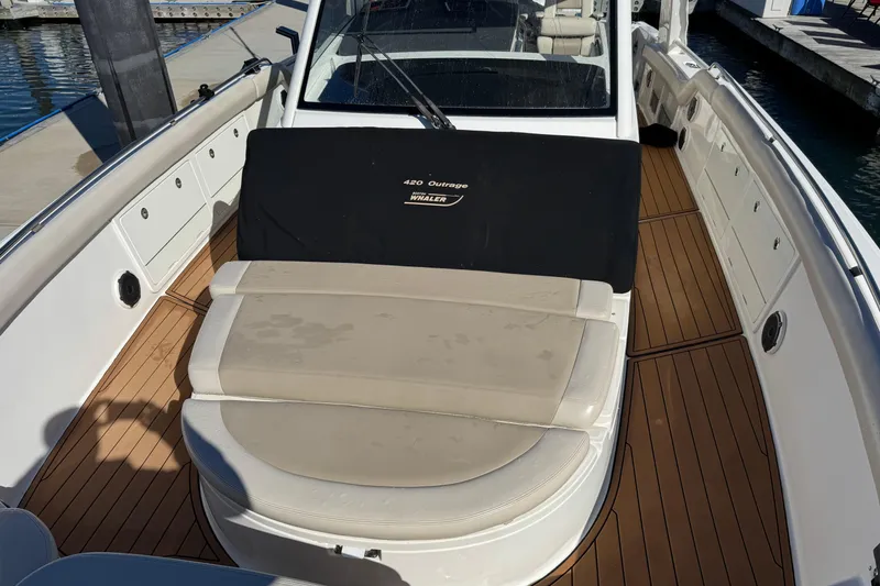 Slide: The Image of 2020 Boston Whaler 420 Outrage boat with cushioned seating and teak flooring. - 18