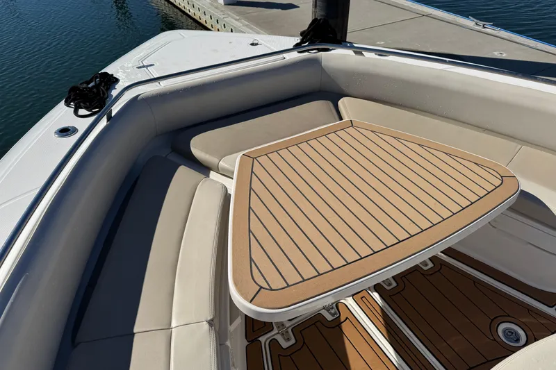 Slide: The Image of 2020 Boston Whaler 420 Outrage boat interior with cushioned seating and wooden table. - 19