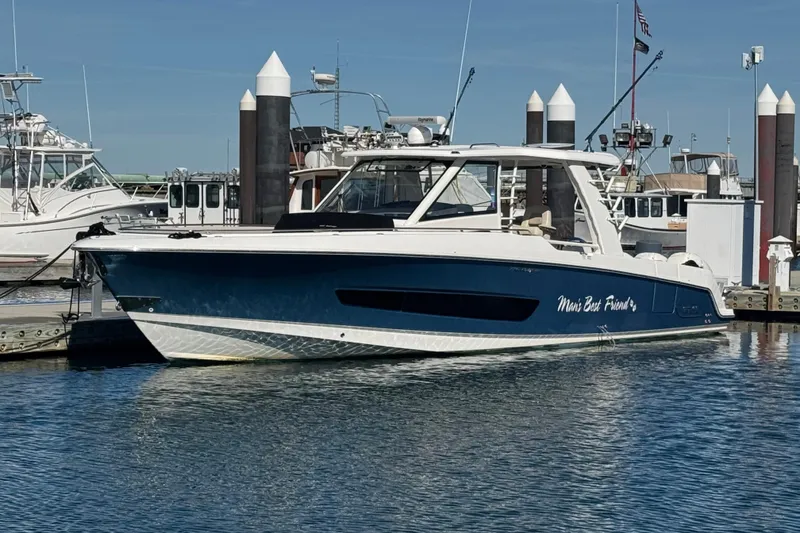 Slide: The Image of 2020 Boston Whaler 420 Outrage docked at marina, blue and white design. - 2