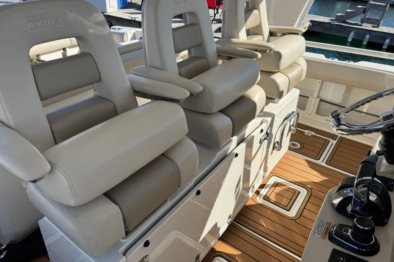 Slide: The Image of Luxury seating on 2020 Boston Whaler 420 Outrage boat, featuring premium helm chairs and teak flooring. - 27