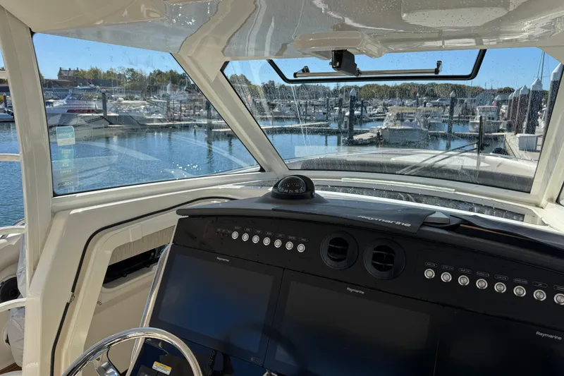 Slide: The Image of Interior view of 2020 Boston Whaler 420 Outrage boat cockpit with marina background. - 29