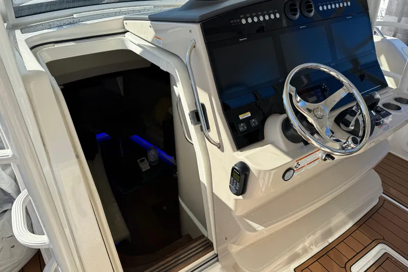 Slide: The Image of 2020 Boston Whaler 420 Outrage helm with modern controls and cabin entrance. - 30