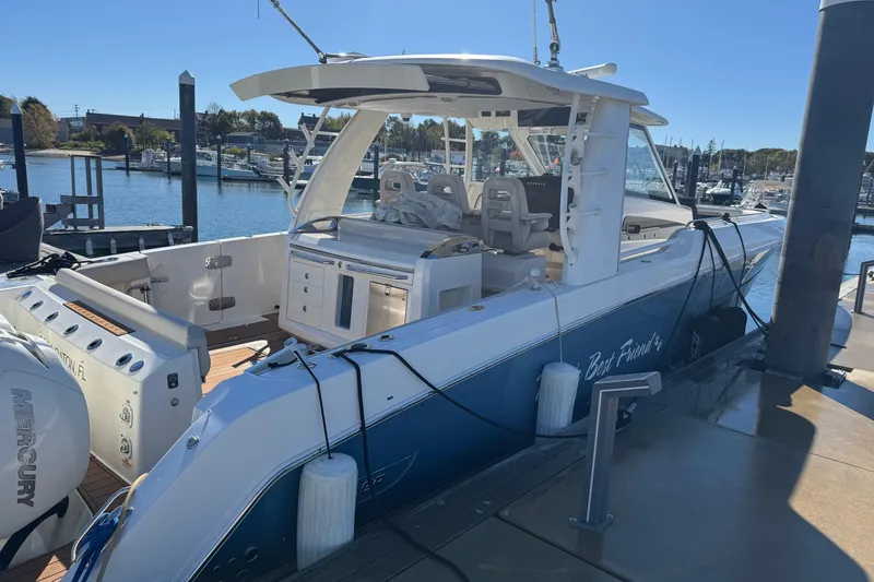 Slide: The Image of 2020 Boston Whaler 420 Outrage docked at marina, showcasing sleek design and spacious deck. - 4