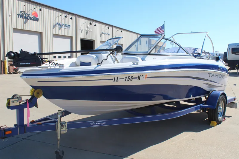 Slide: The Image of 2008 Tahoe Q5i SF boat on trailer outside dealership, blue and white design. - 1