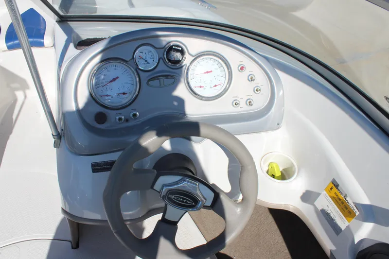 Slide: The Image of Steering wheel and dashboard of 2008 Tahoe Q5i SF boat, featuring gauges and controls. - 12