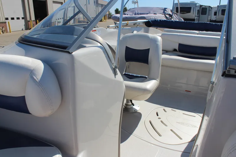 Slide: The Image of 2008 Tahoe Q5i SF boat interior with white and blue seating, docked near RVs. - 19