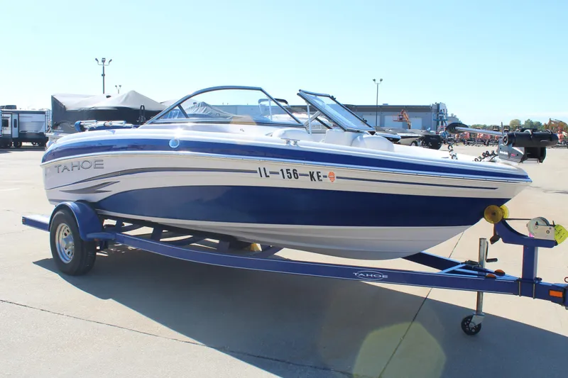 Slide: The Image of 2008 Tahoe Q5i SF boat on trailer, blue and white design, parked outdoors. - 2