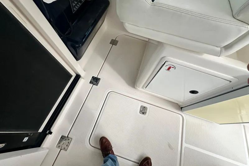 Slide: The Image of 2004 Tiara Yachts 3500 Open interior, featuring white seating and storage compartments. - 12