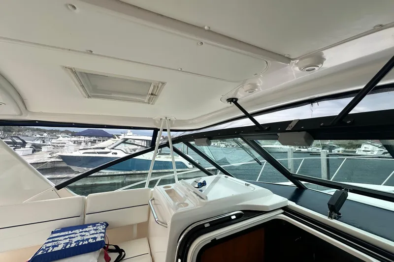 Slide: The Image of Interior view of 2004 Tiara Yachts 3500 Open, showcasing helm and marina backdrop. - 21