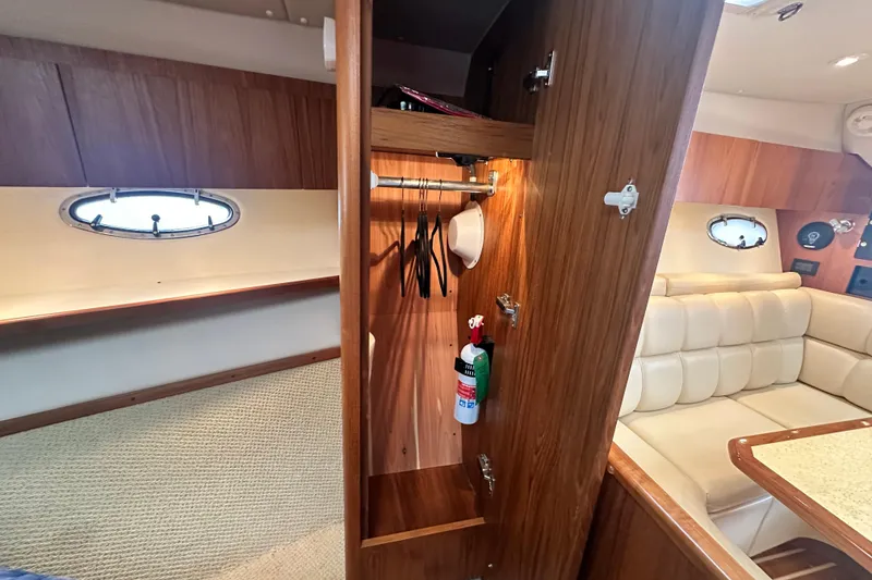 Slide: The Image of Interior of 2004 Tiara Yachts 3500 Open, featuring wood cabinetry and seating area. - 24