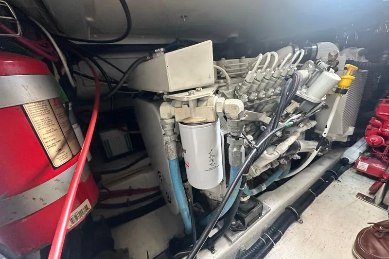 Slide: The Image of Engine compartment of 2004 Tiara Yachts 3500 Open, featuring mechanical components and fire extinguisher. - 34