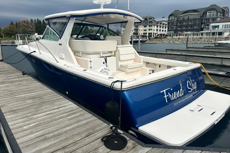 Slide: The Image of 2004 Tiara Yachts 3500 Open docked at marina, blue hull, spacious deck. - 4