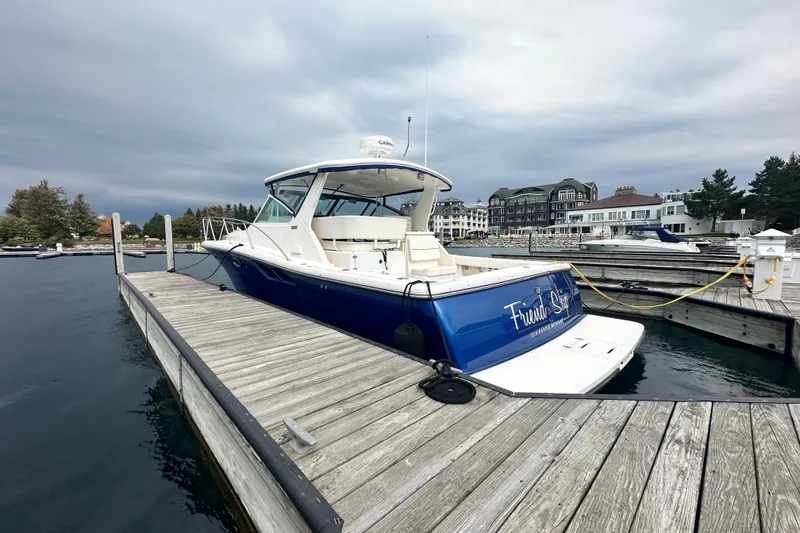 Slide: The Image of 2004 Tiara Yachts 3500 Open docked at a marina under cloudy skies. - 5