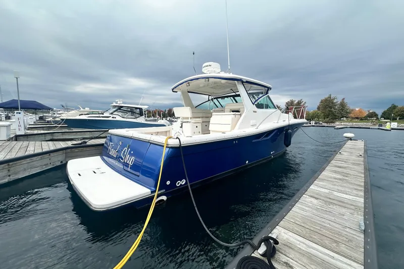 Slide: The Image of 2004 Tiara Yachts 3500 Open docked, showcasing sleek design and spacious deck. - 6