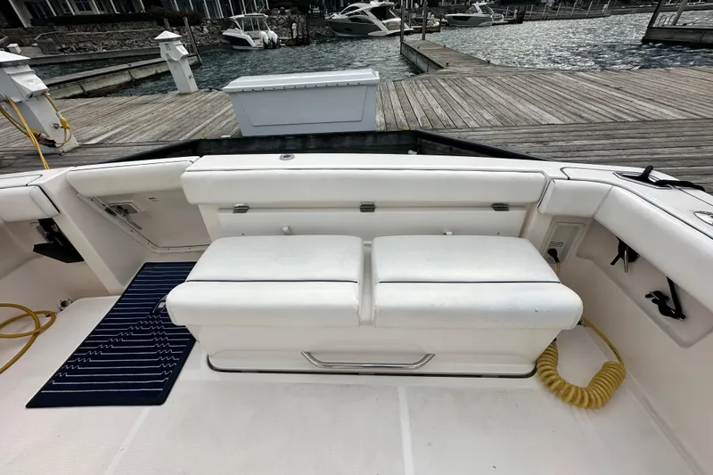 Slide: The Image of 2004 Tiara Yachts 3500 Open boat interior with white seating and dock view. - 7