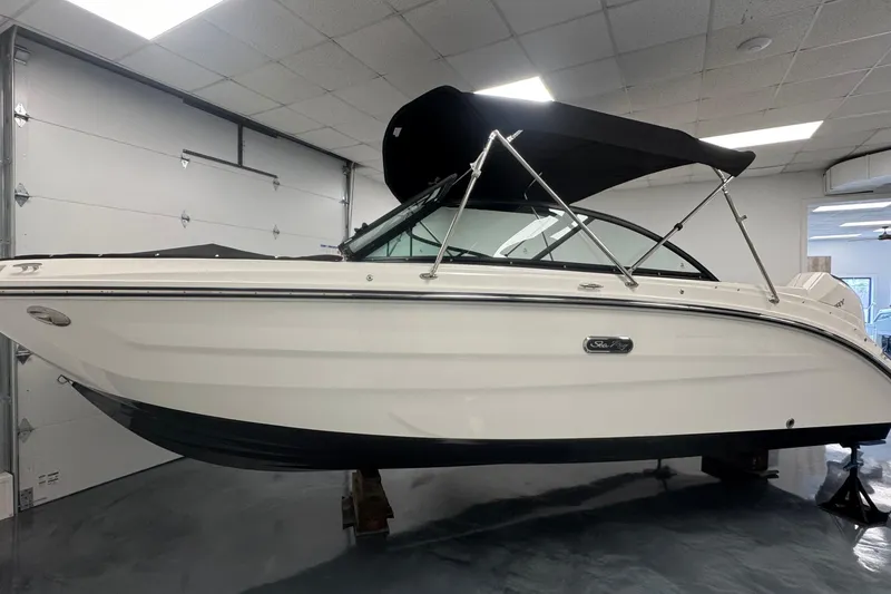 Slide: The Image of 2026 Sea Ray SDX 230 Outboard boat in showroom, featuring sleek design and black canopy. - 1