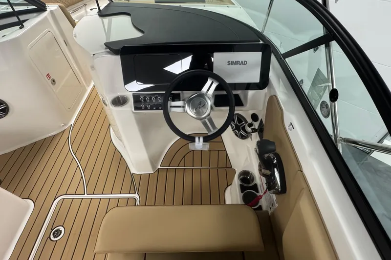 Slide: The Image of 2026 Sea Ray SDX 230 Outboard helm with Simrad display and tan seating. - 14