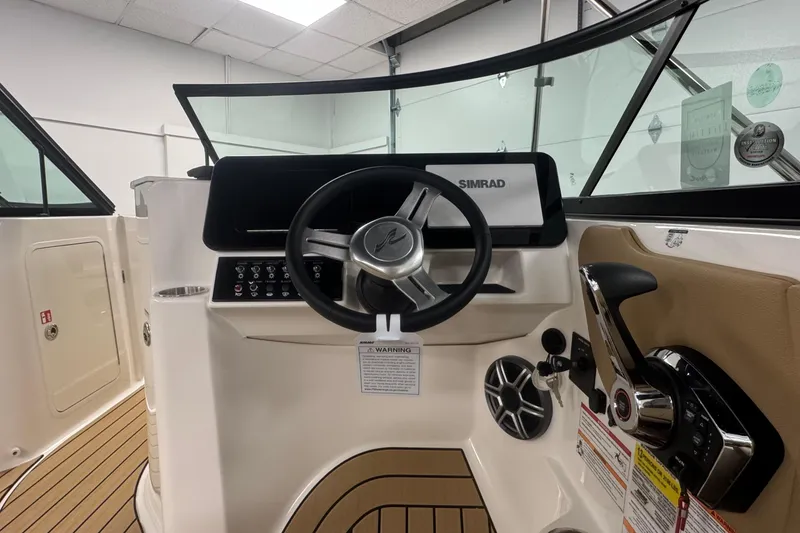 Slide: The Image of 2026 Sea Ray SDX 230 Outboard helm with steering wheel and control panel. - 15