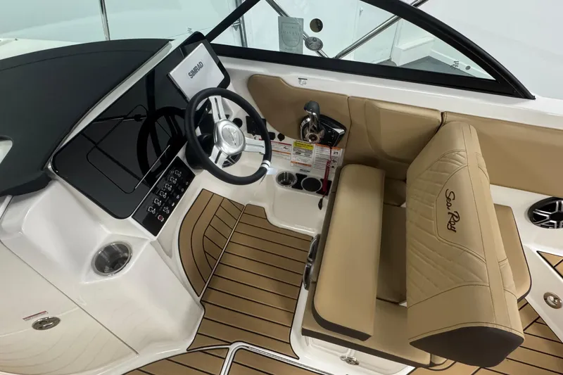 Slide: The Image of 2026 Sea Ray SDX 230 Outboard cockpit with tan seating and modern dashboard. - 16
