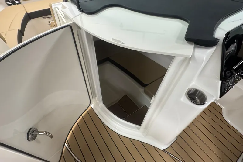 Slide: The Image of 2026 Sea Ray SDX 230 Outboard interior with open cabin door and teak flooring. - 20