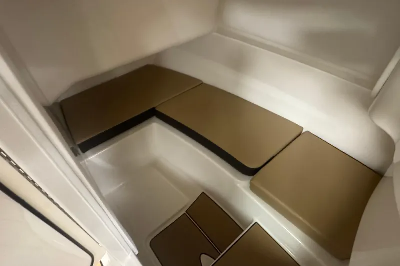 Slide: The Image of Interior cabin of 2026 Sea Ray SDX 230 Outboard with cushioned seating. - 22