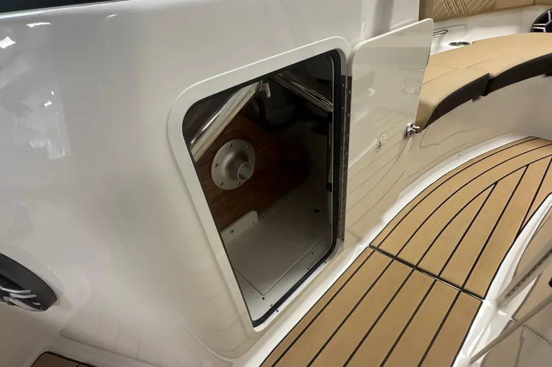 Slide: The Image of 2026 Sea Ray SDX 230 Outboard boat interior with open storage compartment and teak flooring. - 23
