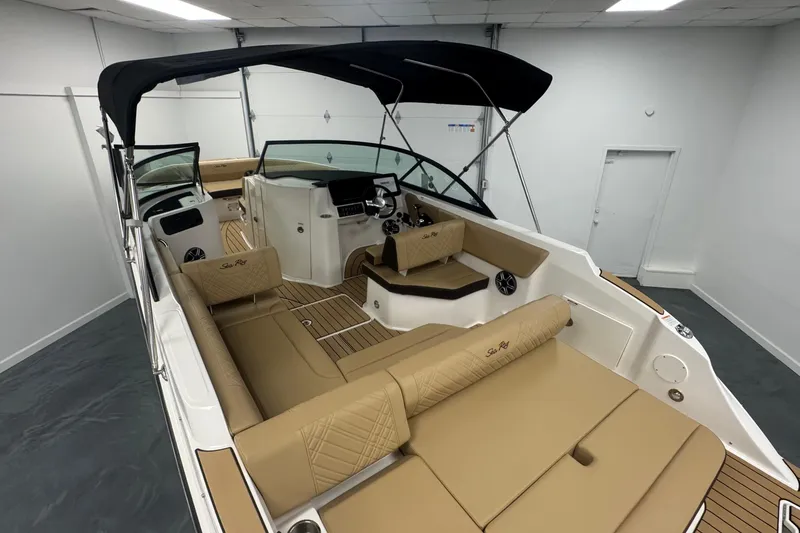 Slide: The Image of 2026 Sea Ray SDX 230 Outboard boat interior with tan seating and black canopy. - 8