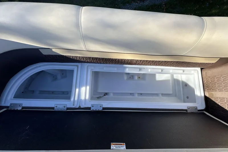 Slide: The Image of Open storage compartment on 2020 Godfrey Marine 22 boat with cushioned seating. - 13