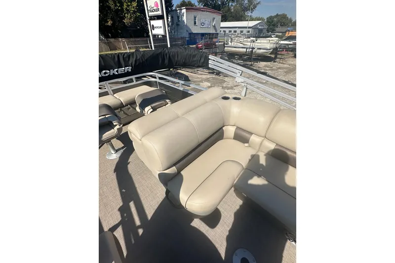 Slide: The Image of 2024 Sun Tracker Fishin' Barge 22 DLX with beige seating, outdoor display. - 13