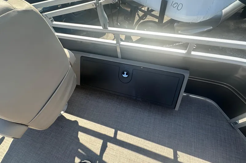 Slide: The Image of 2024 Sun Tracker Fishin' Barge 22 DLX interior with seating and storage compartment. - 16