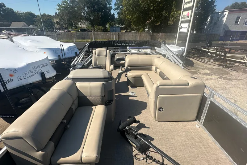 Slide: The Image of 2024 Sun Tracker Fishin' Barge 22 DLX with beige seating and spacious deck layout. - 6