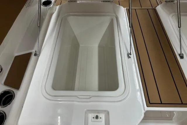 Slide: The Image of 2026 Chaparral 250 OSX boat interior with open storage compartments and tan seating. - 17