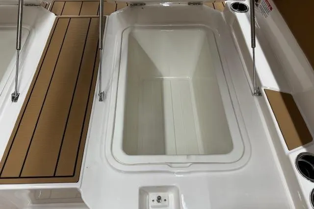 Slide: The Image of 2026 Chaparral 250 OSX boat deck with storage compartment and teak-style flooring. - 18