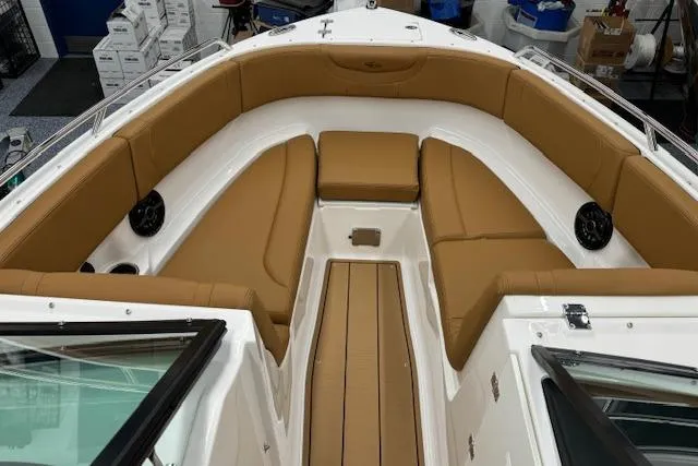 Slide: The Image of 2026 Chaparral 250 OSX boat with tan seating and sleek design in showroom. - 2