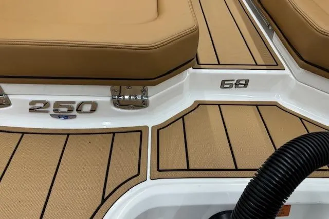 Slide: The Image of 2026 Chaparral 250 OSX boat interior with tan seating and flooring. - 26