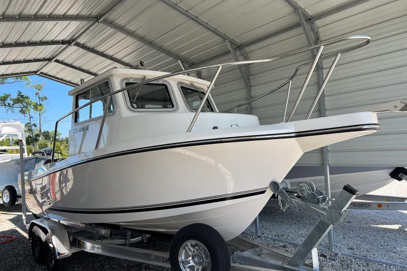 Slide: The Image of 2026 Defiance Admiral 220 EX boat with Yamaha 200 outboard motor, displayed outdoors. - 2