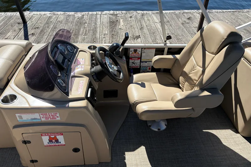 Slide: The Image of 2021 G3 SunCatcher Fusion 325RCX boat cockpit with beige captain's chair and control panel. - 8