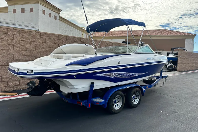 Slide: The Image of 2006 Rinker 226 Captiva Bowrider on trailer, parked with scenic background. - 2