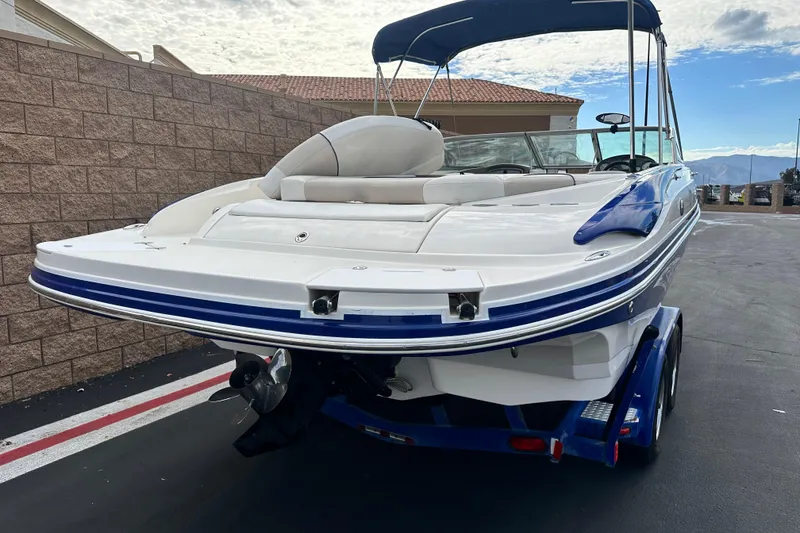 Slide: The Image of 2006 Rinker 226 Captiva Bowrider boat on trailer, rear view, parked outdoors. - 3