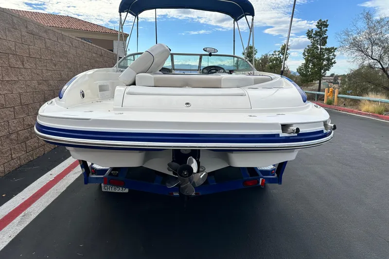 Slide: The Image of 2006 Rinker 226 Captiva Bowrider boat with blue accents on a trailer. - 4