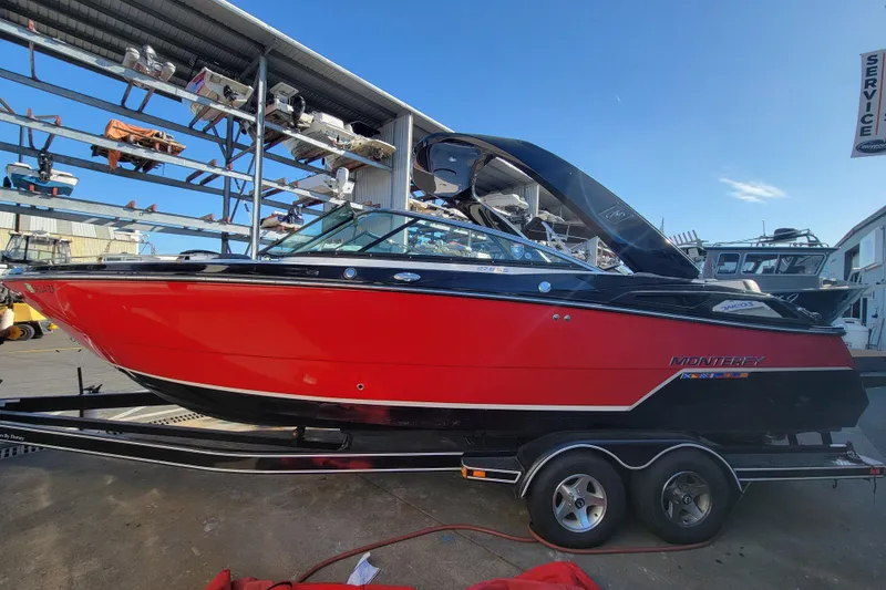 The Image of 2018 Monterey 278SS Super Sport boat in vibrant red on a trailer at a marina. - 0